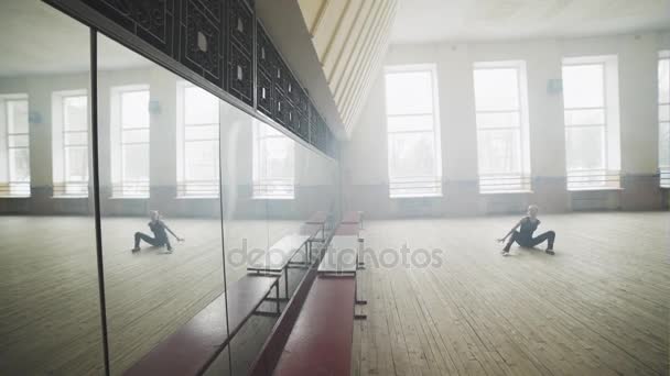 Bela bailarina graciosa na posição de balé arabesco de prática preta perto da grande janela no corredor leve. Treinamento de classe de balé, tonificação suave de alta tecla . — Vídeo de Stock