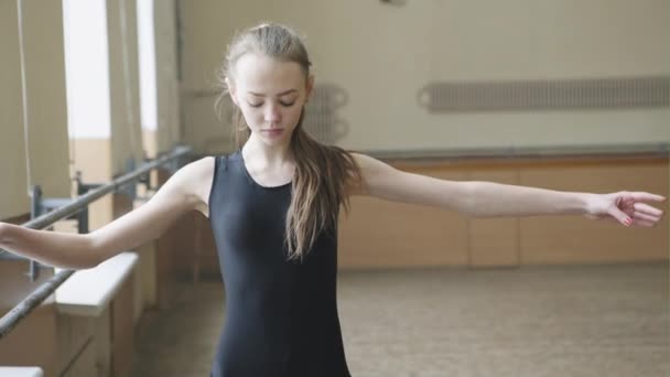 Mooie sierlijke ballerine praktijk ballet posities in de buurt van groot raam in witte lichte hal. Ballet klasse opleiding, high-key zachte toning — Stockvideo