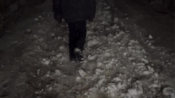 Одинокий и бедный мальчик уходит в подземный туннель в зимний снег и пытается выжить — стоковое видео