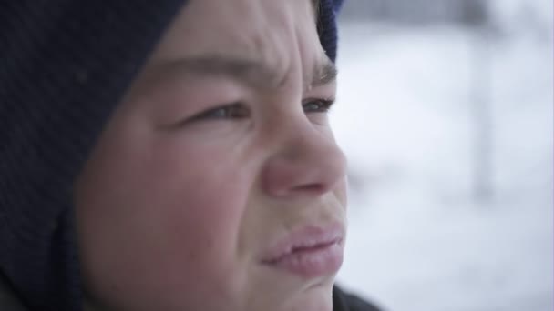 Porträt eines kleinen Jungen mit armseligem, wenig Licht im Wald während des harten Winters — Stockvideo