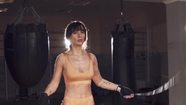 Красивая атлетичная девушка использует скакалки для тренировки в тренажерном зале — стоковое видео