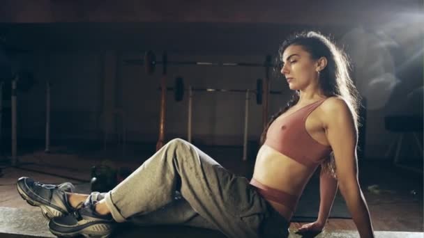 Flexible jeune femme étirant sa jambe droite dans le gymnase — Video