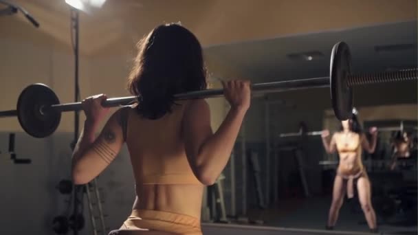 Donna sportiva che fa accovacciata con un bilanciere in palestra — Video Stock