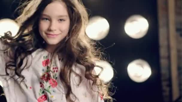 Glückliches kleines Mädchen tanzt auf schwarzem Hintergrund — Stockvideo