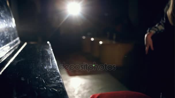 Girl is trying to play on an old black piano — Stock Video