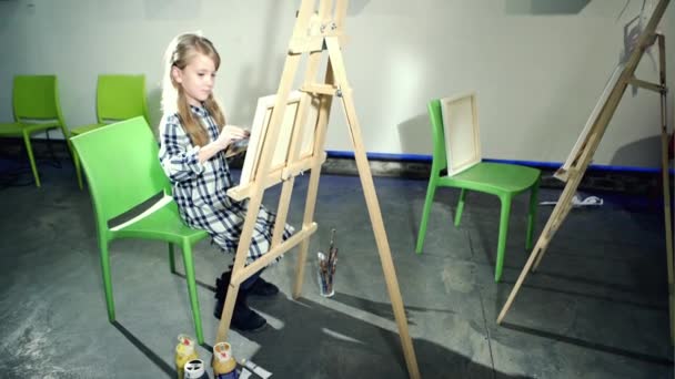 Linda niña está dibujando con pincel y pintura . — Vídeo de stock