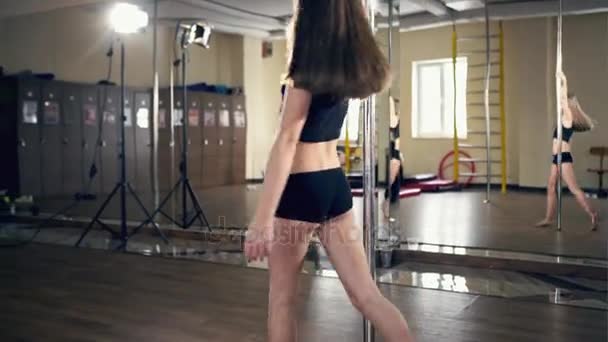 Jong meisje gymnast in sportschool neemt pole dans — Stockvideo