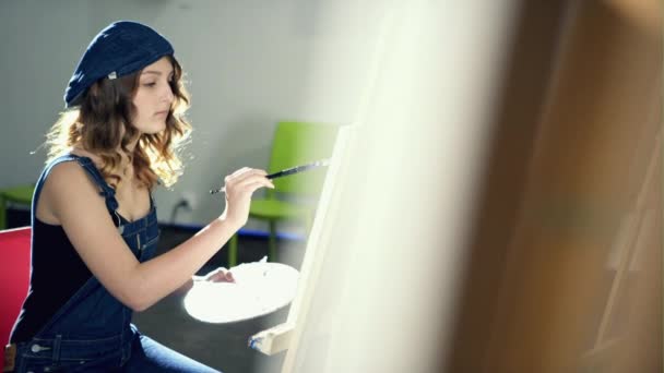 Молодая женщина рисует картину — стоковое видео