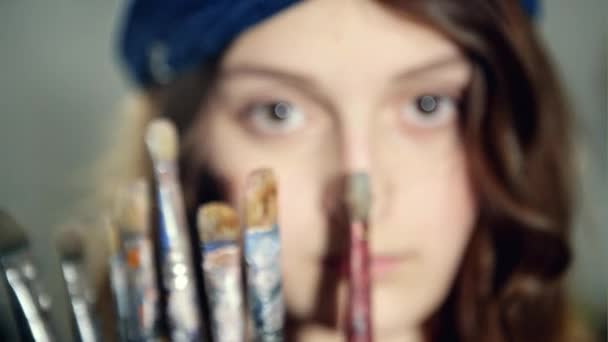 Feminino posando com um conjunto de escovas usadas para pintar imagens — Vídeo de Stock