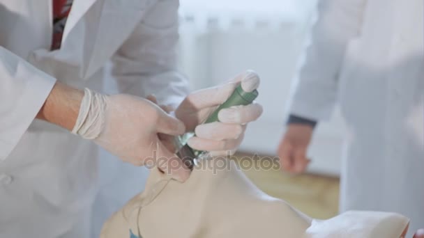 Estudiantes colocando un tubo en la garganta humana — Vídeos de Stock