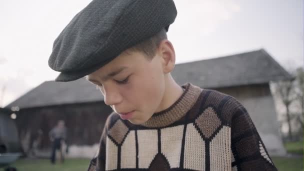 Bambino bere latte e mangiare un pezzo di pane in un villaggio al tramonto — Video Stock