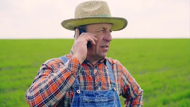 Senior man in hat telefoon praten — Stockvideo