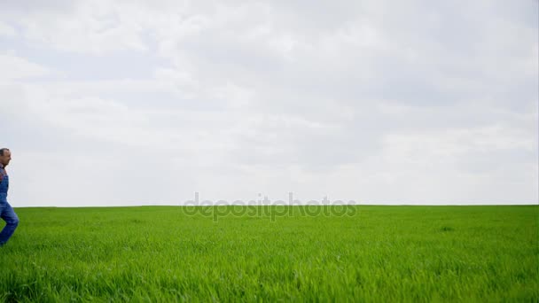 Agricoltore anziano a piedi attraverso il campo — Video Stock