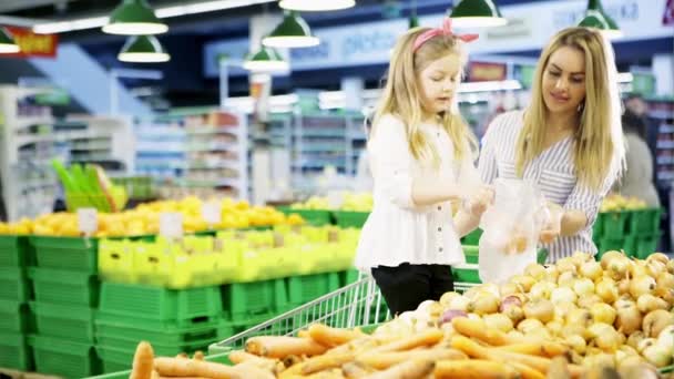 Mujer e hija comprando cebolla — Vídeos de Stock