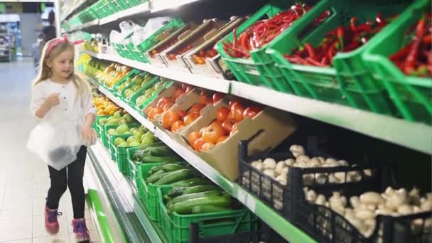 Jovencita independientemente compra comida en un supermercado — Vídeo de stock