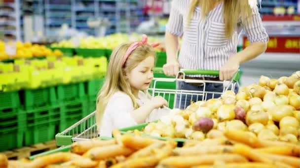 Madre e hija haciendo compras en una tienda de comestibles y están felices por ello — Vídeos de Stock