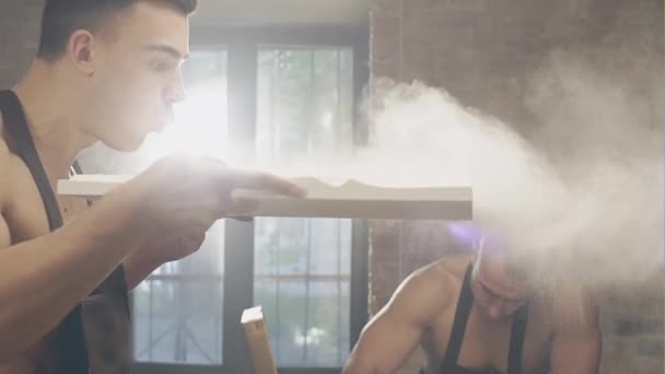 Человек, сдувающий пыль в студии — стоковое видео
