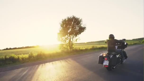 Mężczyzna jazdy road w zachód słońca — Wideo stockowe