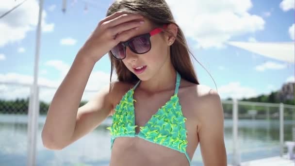 Chica joven en bikini moviendo su cabello — Vídeo de stock