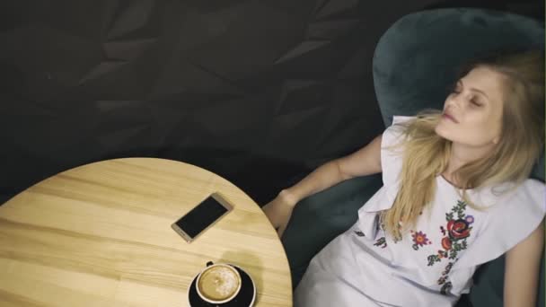 Jonge vrouw in leunstoel ontspannen — Stockvideo