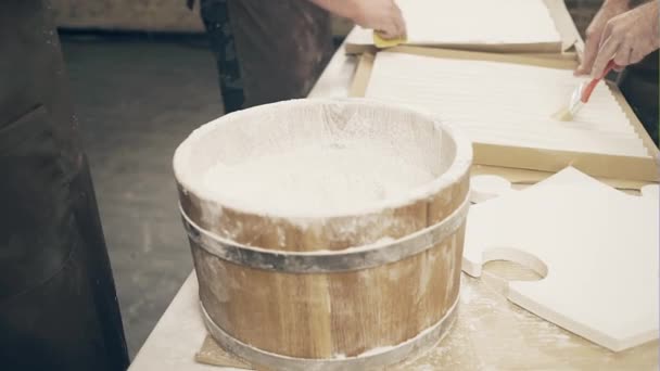 Svalnatý muž míchá směs sádry v ručně vyrobené workshop, který je dekorativní sádrové panely. — Stock video