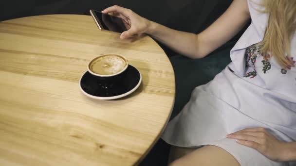 Young attractive girl holding a mobile phone while dreaming about something — Stock Video