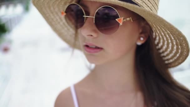 年轻漂亮的女孩，在一顶帽子和太阳镜上海滩 — 图库视频影像