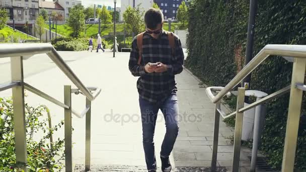 Man met telefoon wandelen op straat — Stockvideo