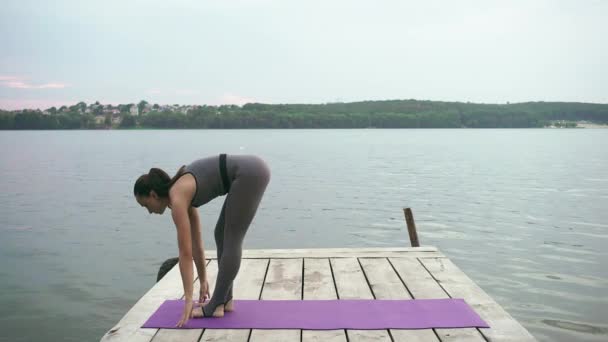 Mujer caucásica practicando yoga en la orilla del mar — Vídeo de stock