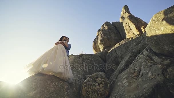 Πρόσφατα παντρεμένος ζευγάρι στέκεται πάνω σε πέτρα — Αρχείο Βίντεο