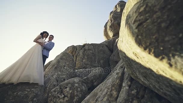 Красива весільна пара стоїть на ракетному пагорбі — стокове відео