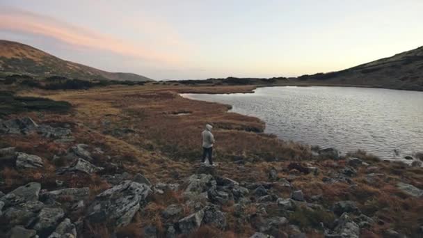 Человек, стоящий на холме и смотрящий на озеро Тоба — стоковое видео