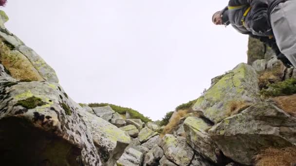 Vastberaden jonge man klimmen een rotsachtige berg — Stockvideo