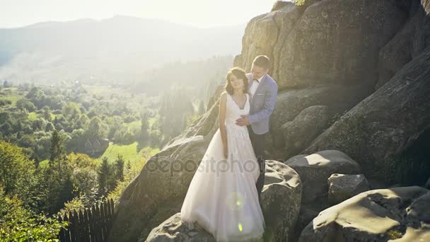 Casamento lindo casal beijando e abraçando perto da costa de um rio de montanha com pedras — Vídeo de Stock