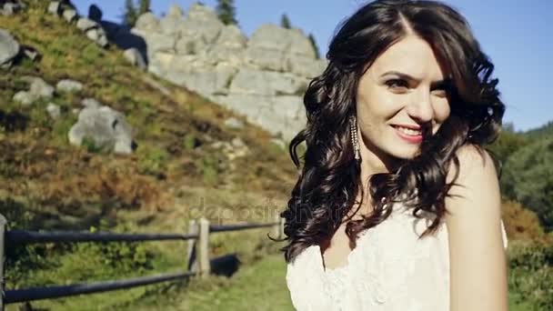 La bella sposa ride felicemente della macchina fotografica e si sente libera e naturale in una giornata di sole luminoso . — Video Stock