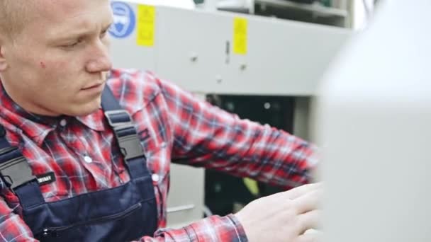 Hombre joven ajustando la máquina industrial — Vídeos de Stock