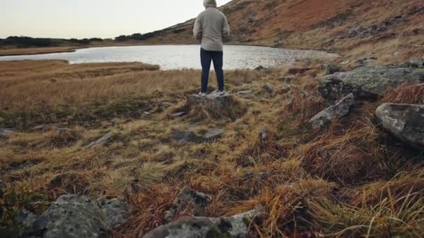 Reiziger Man ontspannen meditatie met serene weergave bergen en meer landschap — Stockvideo