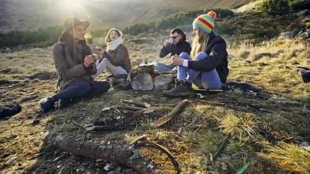Друзья готовят еду над огнем в горах — стоковое видео
