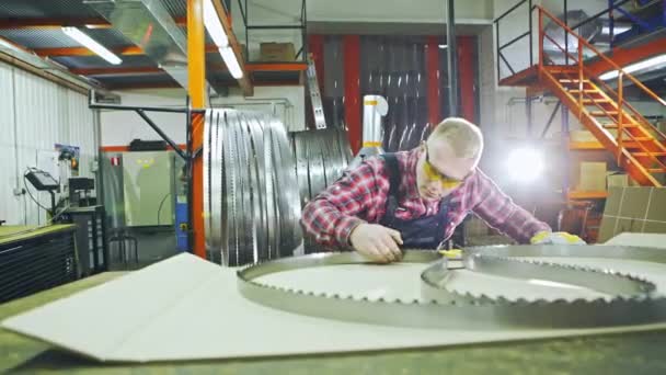 Travailleur inspectant la netteté des dents de scie à ruban — Video