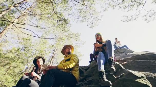 Група друзів, що сидять на скелях у горах — стокове відео