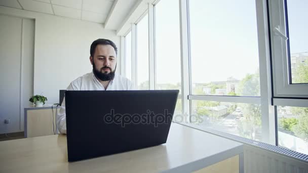 Trabalhador casual usando laptop no escritório — Vídeo de Stock