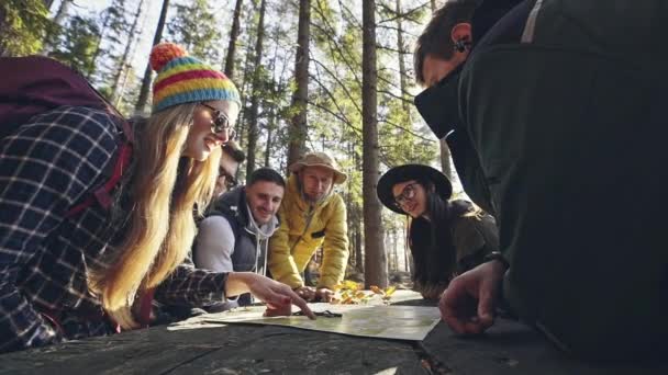 Група людей обговорює карту в лісі — стокове відео