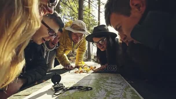 Веселые путешественники, изучающие карту вместе — стоковое видео