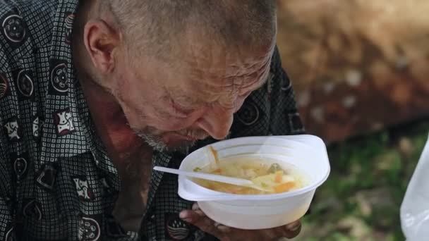 Szegény és éhes magas rangú ember eszik levest portréja — Stock videók