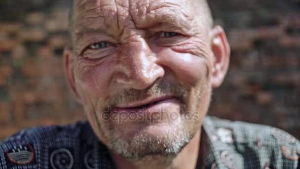 Hombre viejo arrugado sonriendo a la cámara — Vídeos de Stock