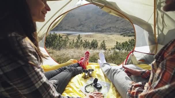 2 つの友人旅行とテントの中で朝のコーヒーを飲みながら時間を過ごします。キャンプで幸せな人は。内部からの眺め。旅行者のカップル — ストック動画