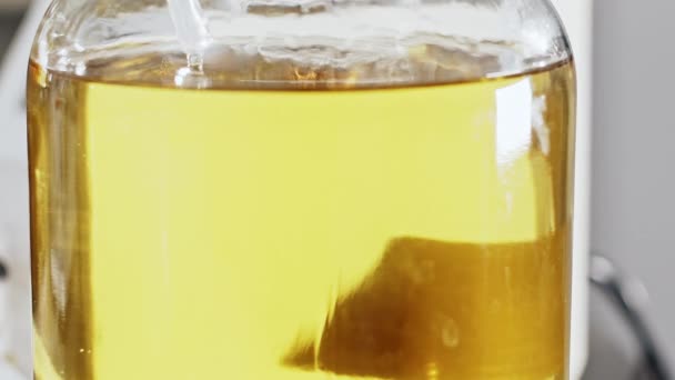Ένα κίτρινο υγρό δοκιμής στο εργαστήριο. Έλεγχος ποιότητας καυσίμου. — Αρχείο Βίντεο