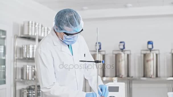 Asystent laboratoryjny przygotować przyrząd do eksperymentu chemicznego w laboratorium. — Wideo stockowe