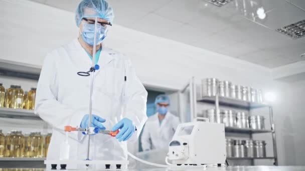 Joven asistente de laboratorio prepara instrumento para experimento químico de laboratorio en laboratorio — Vídeo de stock