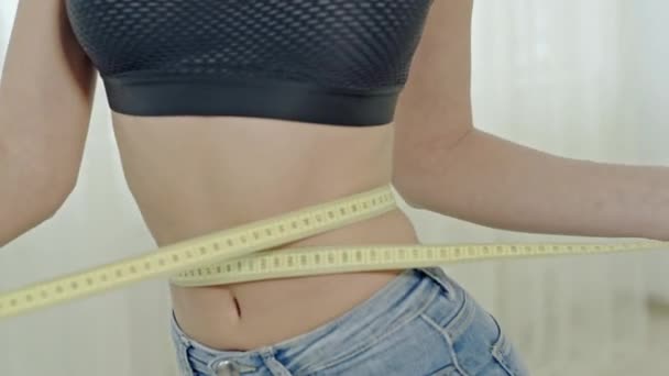 Mujer anónima con cinta métrica alrededor de la cintura — Vídeo de stock